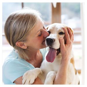 A women giving her dog a kiss