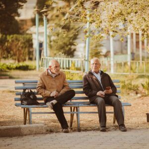 2 seniors hanging out on a bench