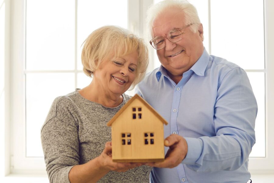 seniors holding a model of a house