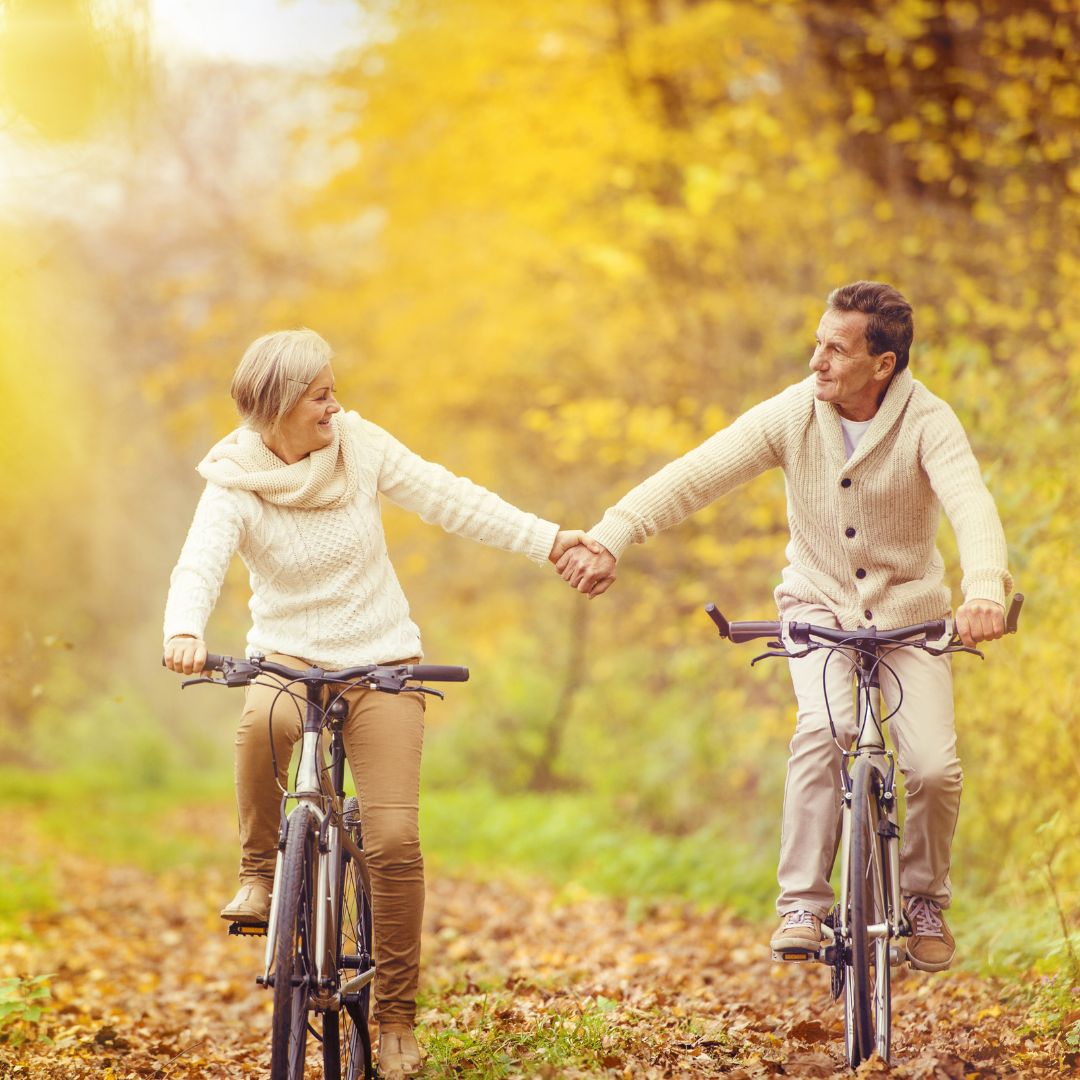 two people biking and holding hands