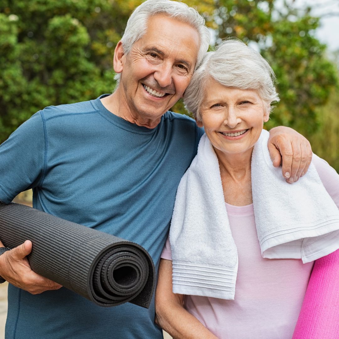 an older couple with yoga mats